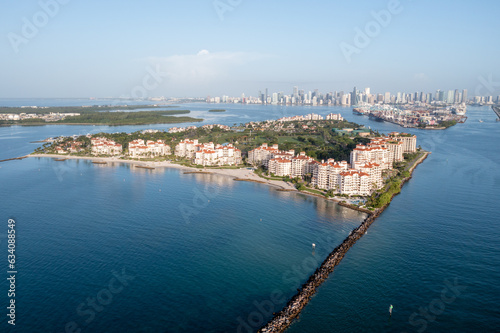Aerial view of Fisher Island at sunrise with City of Miami skyline and Port Miami in background on calm clear summer morning..