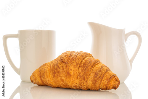 One freshly baked aromatic croissant with white ceramic dish close-up isolated on white.