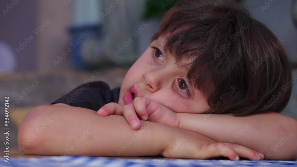 Restless small boy leaning on restaurant table waiting for food to arrive, struggles with boredom. close-up face Restless small boy leaning on restaurant table waiting for food to arrive, struggles with boredom. close-up face