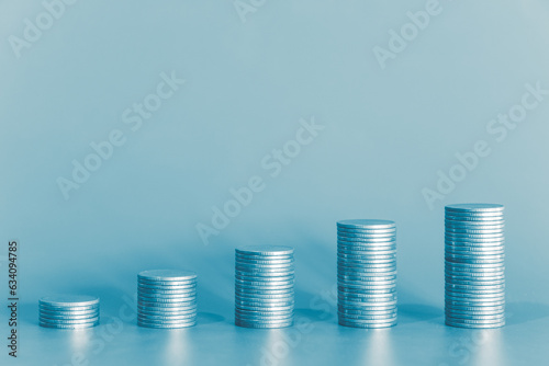 Stack of money coin on blue background with copy space. Business and finance background with blue color filter. 