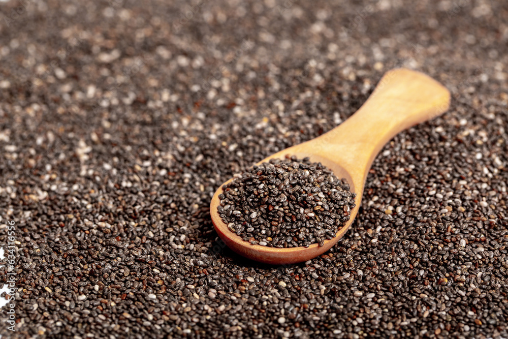 Chia seeds close-up with a wooden spoon. Chia seeds macro. Dry healthy supplement for proper nutrition. Chia seeds close-up with a wooden spoon. Chia seeds macro. Dry healthy supplement for proper nutrition.