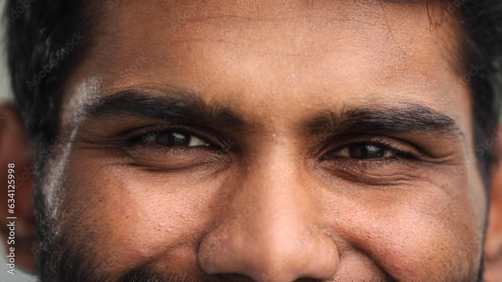 Obraz premium Close-up of the face and eyes of an Indian man in an emotional pose, eyes open, facial wellness concept.