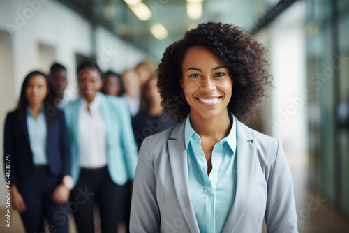 group of people standing in office, confident black woman wearing grey and baby blue suit leading corporate team with confidence 