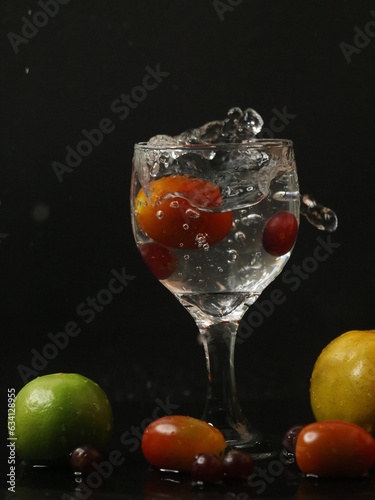 Mixed fruits splashed on wine glasses