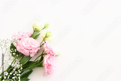Top view image of delicate pink flowers over white background © tomertu