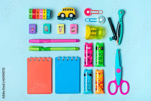 Stationary, back to school, creativity and education concept. Supplies - scissors, pencils, paper clips, note, stapler, calculator, notepad on green background