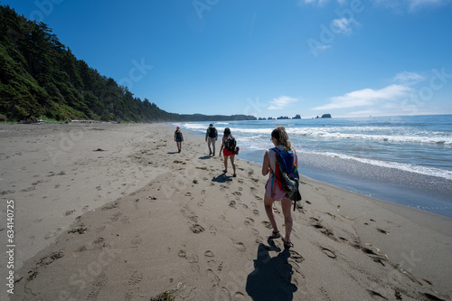 Hikers on Shi Shi Beach Trail in Olympic National Park near Neah Bay, Washington on sunny summer afternoon with Point of Arches in background. photo