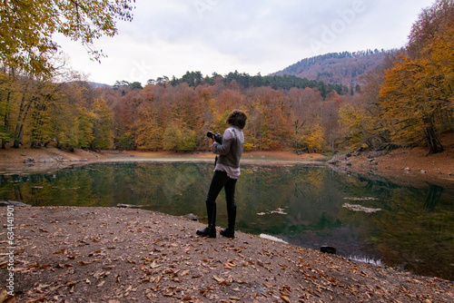 Professional photographer girl watching lake view in autumn. © serhatbozkurt