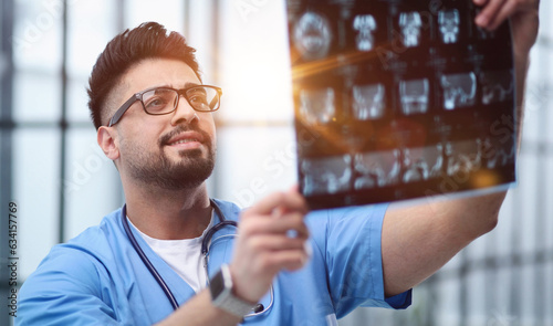 Confident doctor with x-ray picture in office