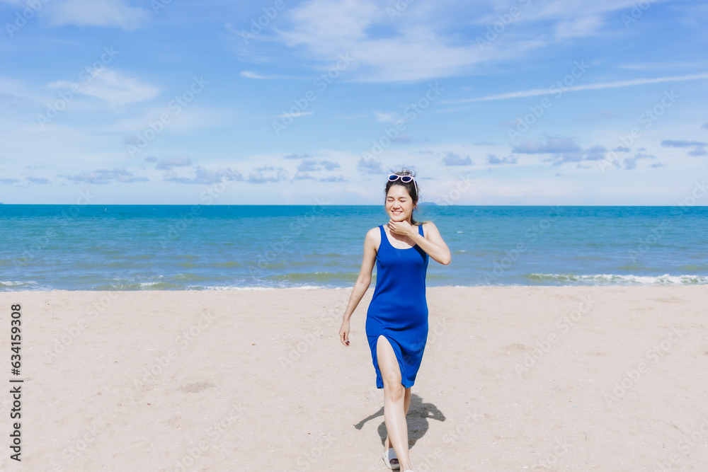 Asian woman walking on the sunny beach feeling the sun burn on her face skin. Asian woman walking on the sunny beach feeling the sun burn on her face skin.