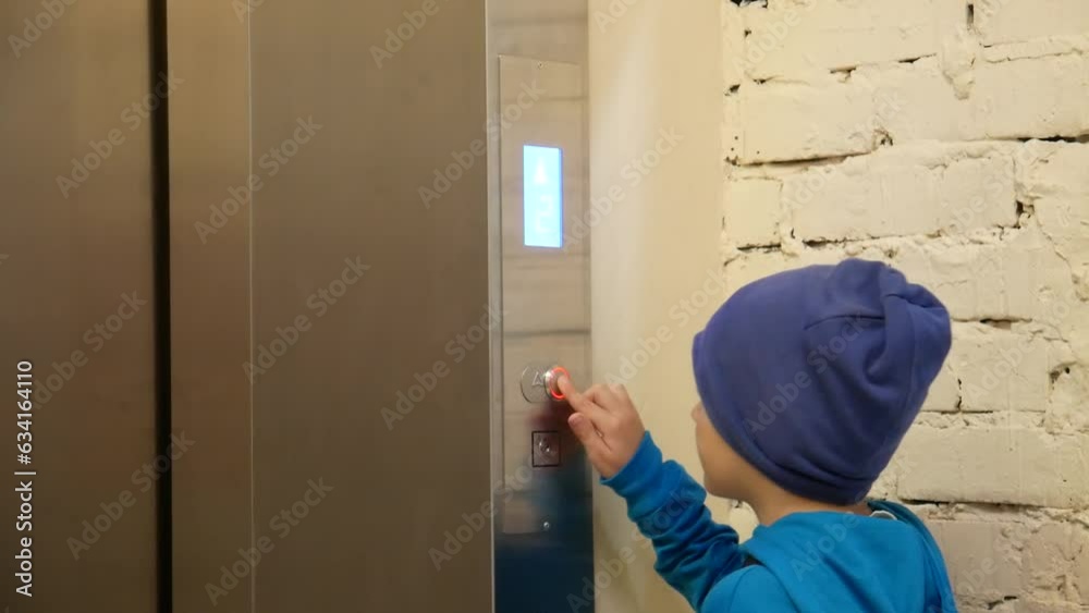 A boy presses the elevator call button