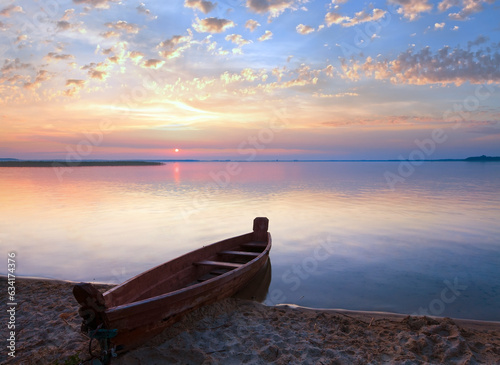 Sunset with boat near the summer lake shore