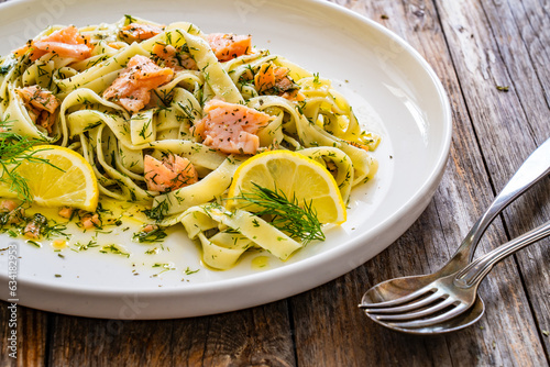 Foto Tagliatelle with salmon and dill on wooden table