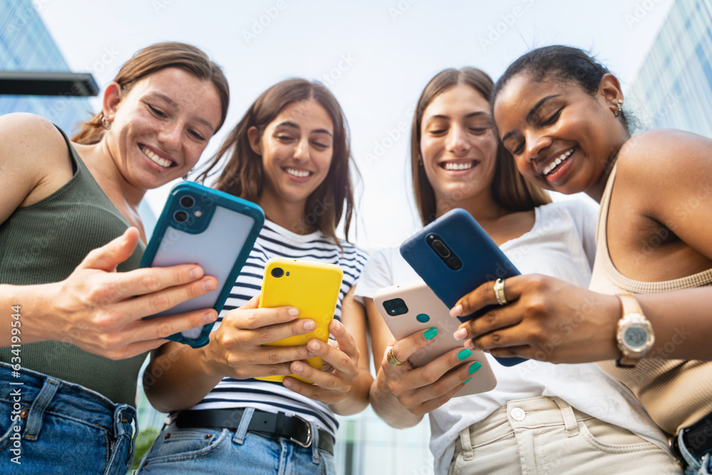 Group of teenage girls using online cell phone app - Female Student friends at University Campus Group of teenage girls using online cell phone app - Female Student friends at University Campus