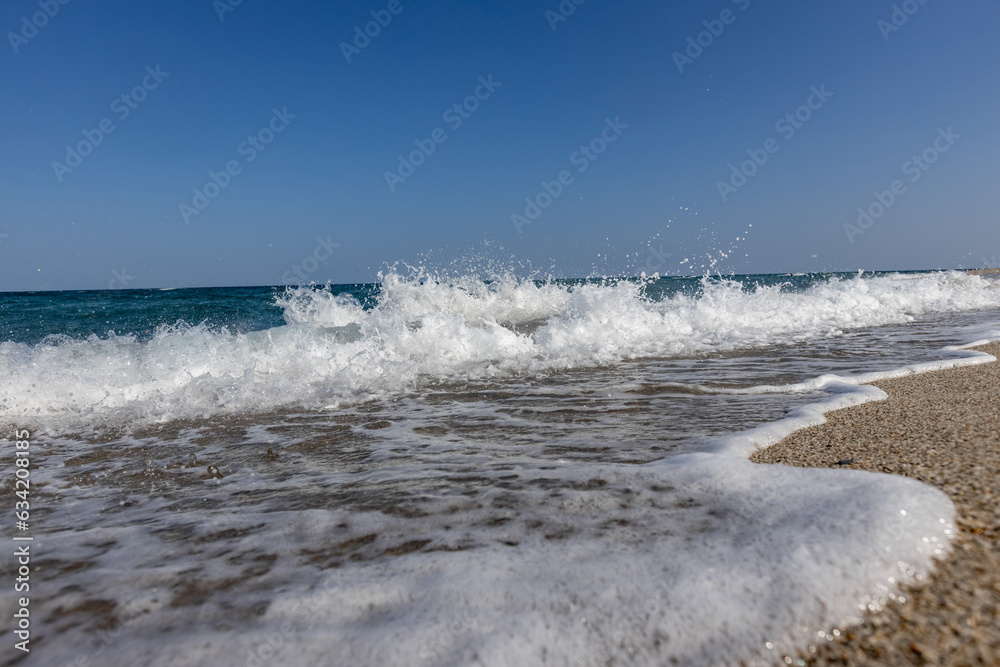 a white waves in the blue sea on the beach