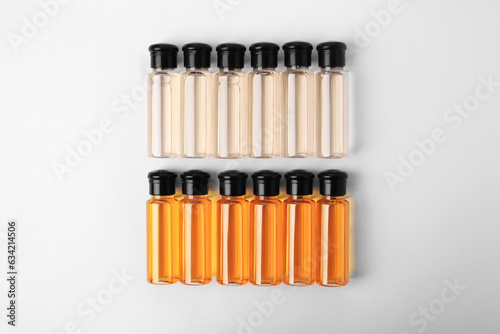 Bottles of cosmetic products on white background  flat lay