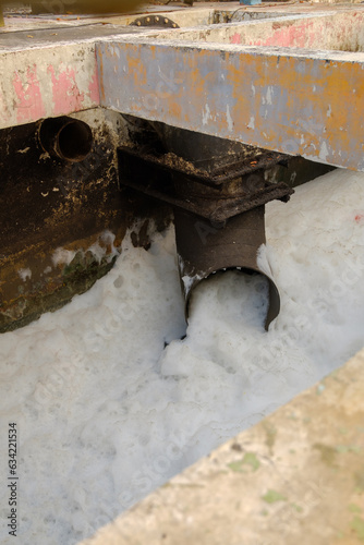 Untreated water into a river. Bad, dirty, untreated water flows from a pipe. environmental pollution by wastewater.