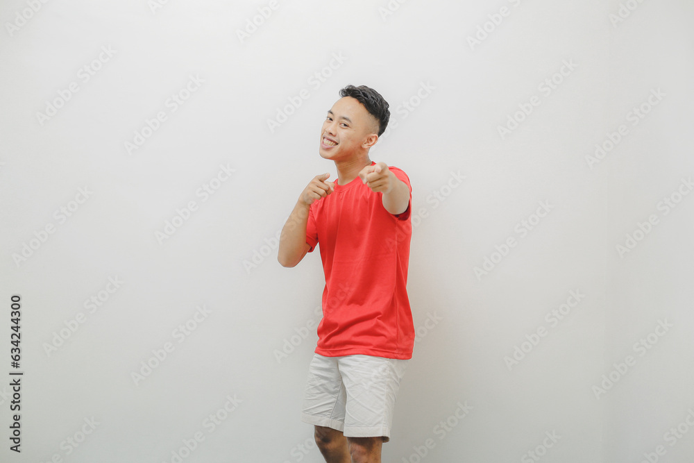 a young man wearing a red shirt on a white background with a cheerful expression a young man wearing a red shirt on a white background with a cheerful expression
