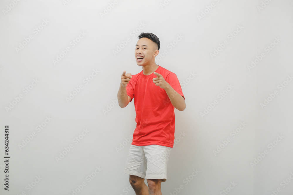a young man wearing a red shirt on a white background with a cheerful expression a young man wearing a red shirt on a white background with a cheerful expression
