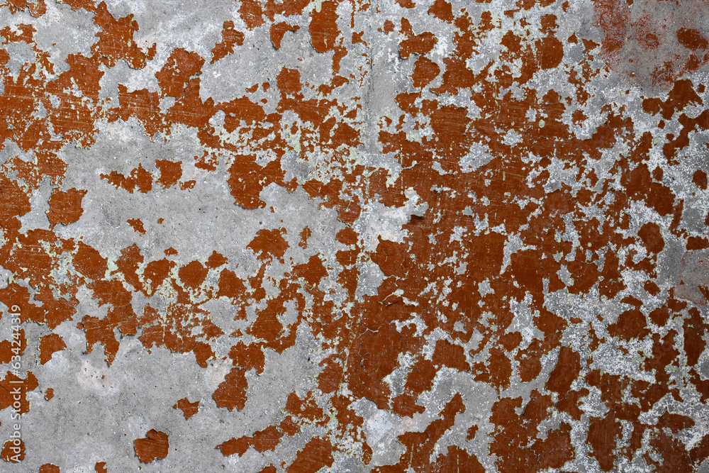 Fototapeta premium Brown peeling paint on the wall. Old concrete wall with cracked flaking paint. Weathered rough painted surface with patterns of cracks and peeling. High resolution texture for background and design.
