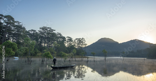 Taken from the back of a man rowing a wooden boat on Tuyen Lam Lake on a beautiful morning in Da Lat Lam Dong Vietnam