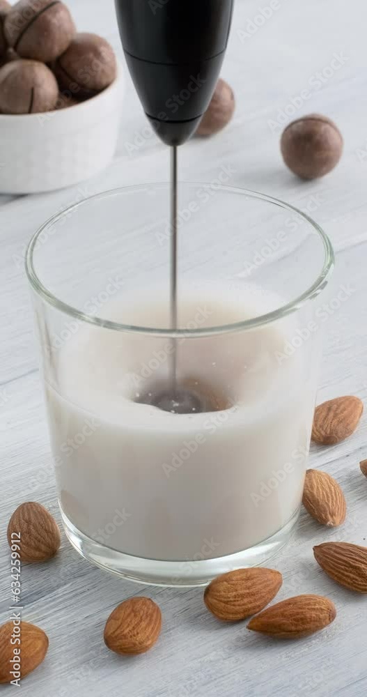 Vidéo Stock Making milk foam with electric milk frother from almond