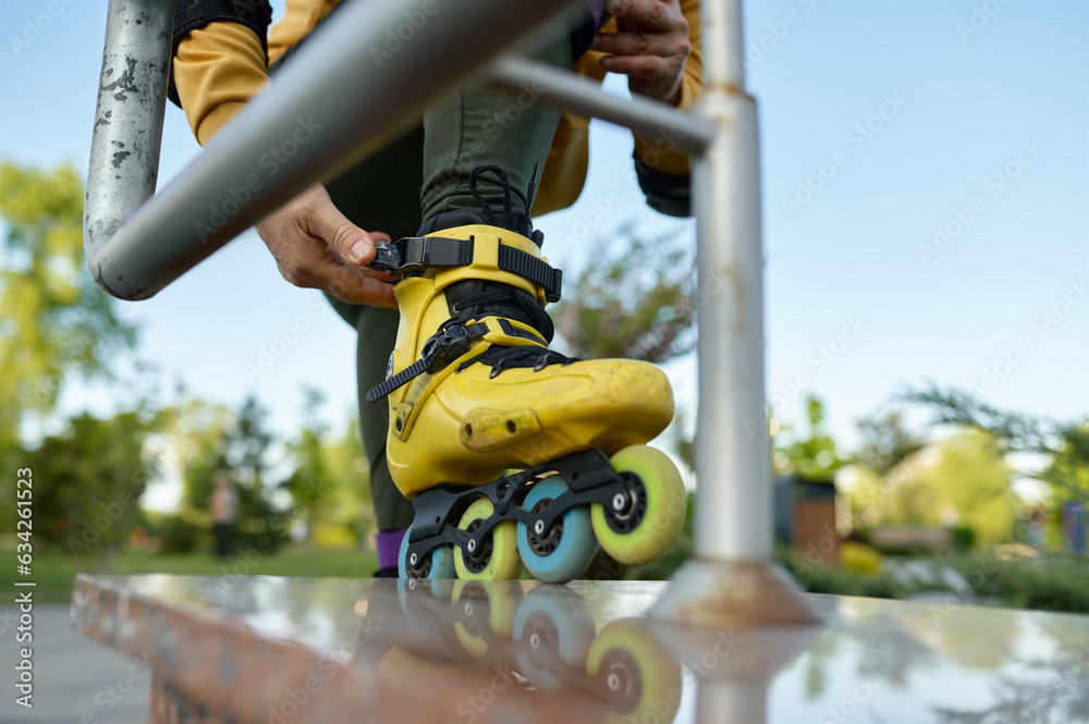 Closeup view on male leg wearing roller skates and hand snapping lock Closeup view on male leg wearing roller skates and hand snapping lock