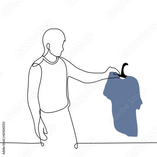 man stands holding a jersey in his hand on a hanger - one line art vector. the concept of choosing a t-shirt, buying men's clothing, shopping