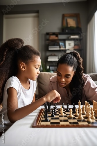 shot of a young woman and her daughter playing chess together at home