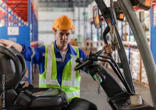 Industrial worker driving a forklift in the factory. The engineer is working and maintaining the warehouse.