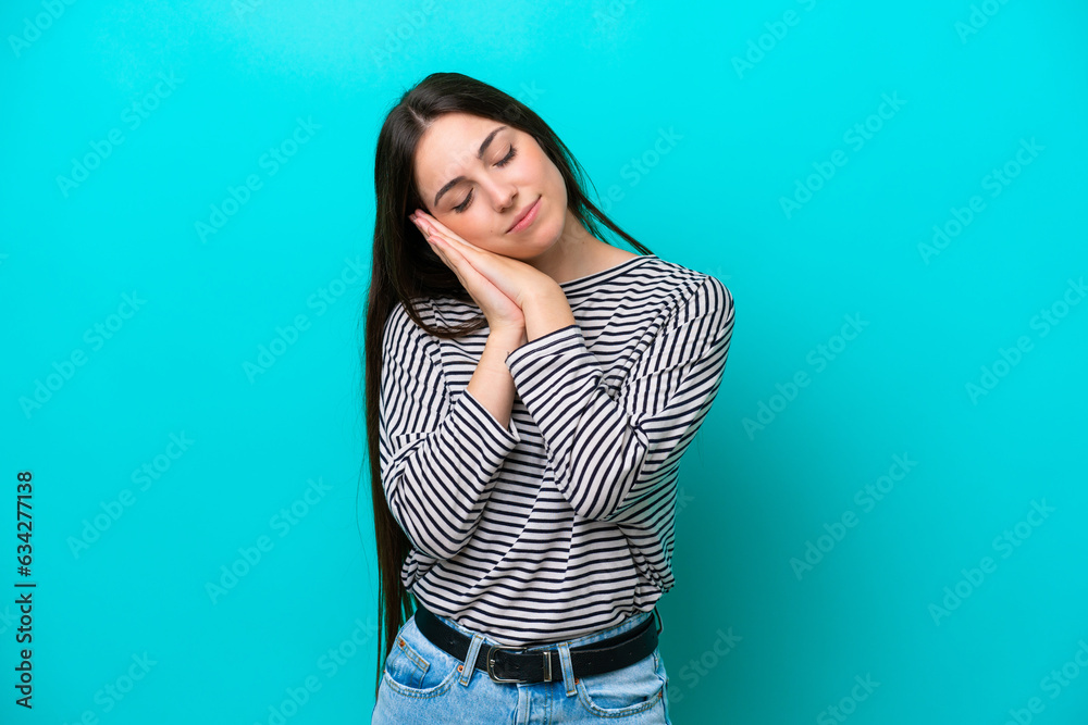 Young caucasian woman isolated on blue background making sleep gesture in dorable expression Young caucasian woman isolated on blue background making sleep gesture in dorable expression
