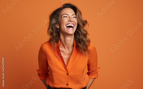 happy 40 years old businesswoman, who is smiling and laughing, wearing bright clothes. orange background, studio photos. created by generative AI technology. photo