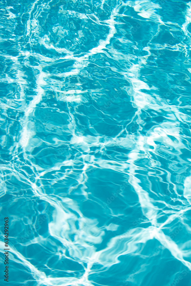 Blue pool water background. Blurred transparent clear calm water surface texture. Water waves in sunlight with copy space.