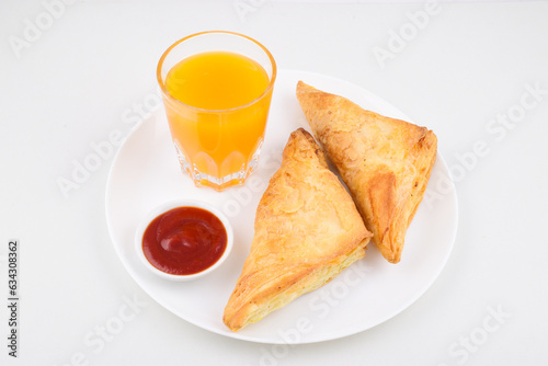 Veg aloo patties in plate with sauce and mango drink on white background