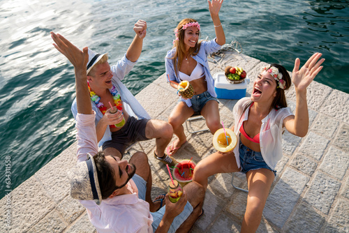 Group of friends having Hawaiian party on summer vacation. People fun travel concept.