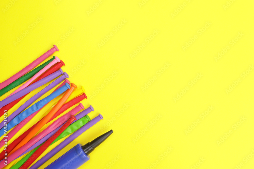Fototapeta premium Latex twisty colored balloons on yellow background