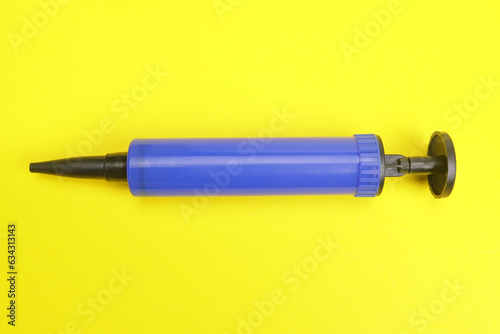 air pump for balloon on yellow background