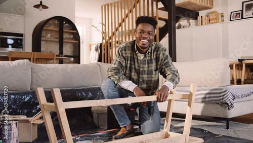 A Black Man Building a Wooden table in the Lounge photo