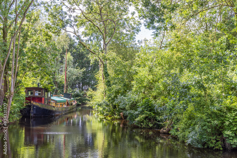 Street view with old flat bottom ship in the center of little village Pieterburen in Het Hogeland Groningen province in The Netherlands,