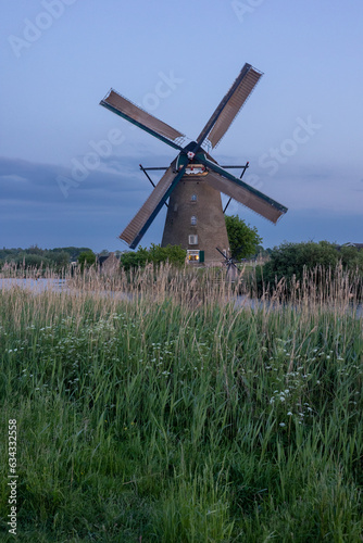 Beautiful wooden windmills at sunset in the Dutch village of Kinderdijk. Windmills run on the wind. The beautiful Dutch canals are filled with water. Beautiful sunset.