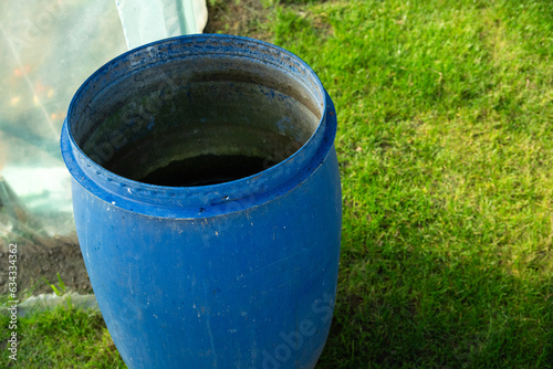 A large plastic barrel standing on the grass