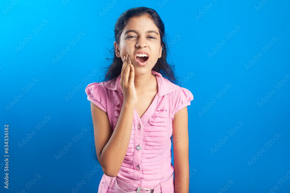 Indian girl touching her cheek due to pain in tooth with painful grimace Indian girl touching her cheek due to pain in tooth with painful grimace