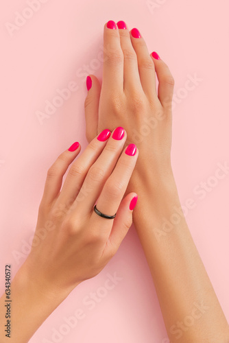 Fototapeta Womans hands with trendy manicure on pastel pink background
