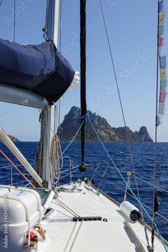 Vertical photo of a sailboat sailing to an island © Martin