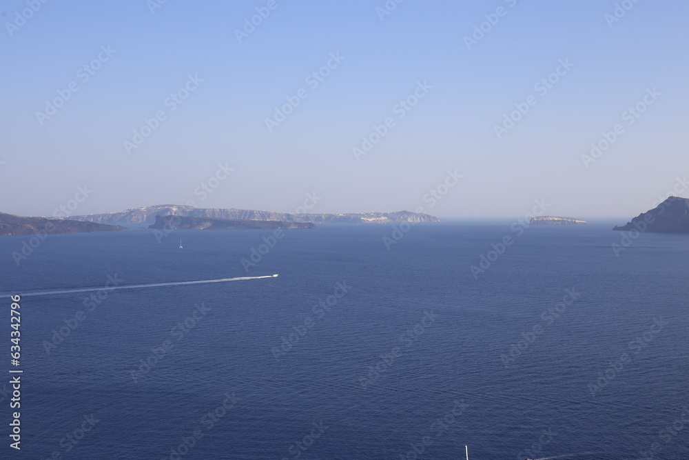 Beautiful scenic view of the Santorini skyline landscape on the Mediterranean Sea with a white cruise ship crossing its bay