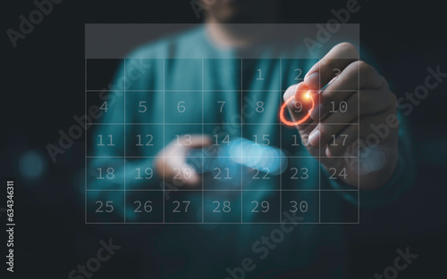 Businessman using pen to writing circle mark on virtual calendar agenda of booking and appointment meeting concept.