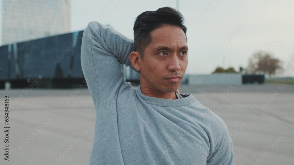 Athlete, guy in sportswear, the guy stretches his arm muscles before training Athlete, guy in sportswear, the guy stretches his arm muscles before training