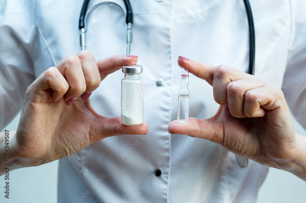 Two ampoules with medicine in the hands of a female doctor, close-up. Two ampoules with medicine in the hands of a female doctor, close-up.