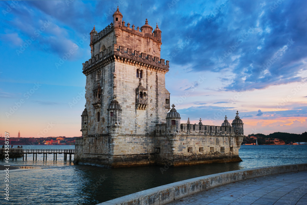 Belem Tower or Tower of St Vincent - famous tourist landmark of Lisboa and tourism attraction - on the bank of the Tagus River (Tejo) in evening dusk after sunset with dramatic sky. Lisbon, Portugal