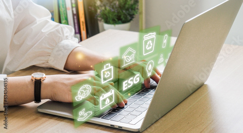 ESG environment social governance investment business concept. Women use a computer to analyze ESG, surrounded by ESG icons .close to the computer screen in business investment strategy concept.